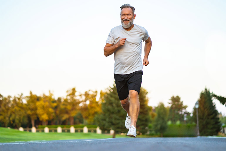 A jogger runs on the shoulder of a road.