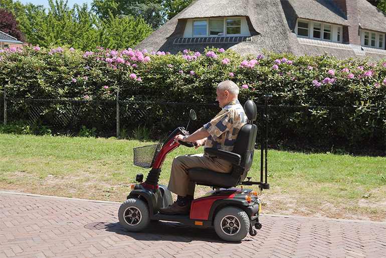 A person drives a scooter on a path.