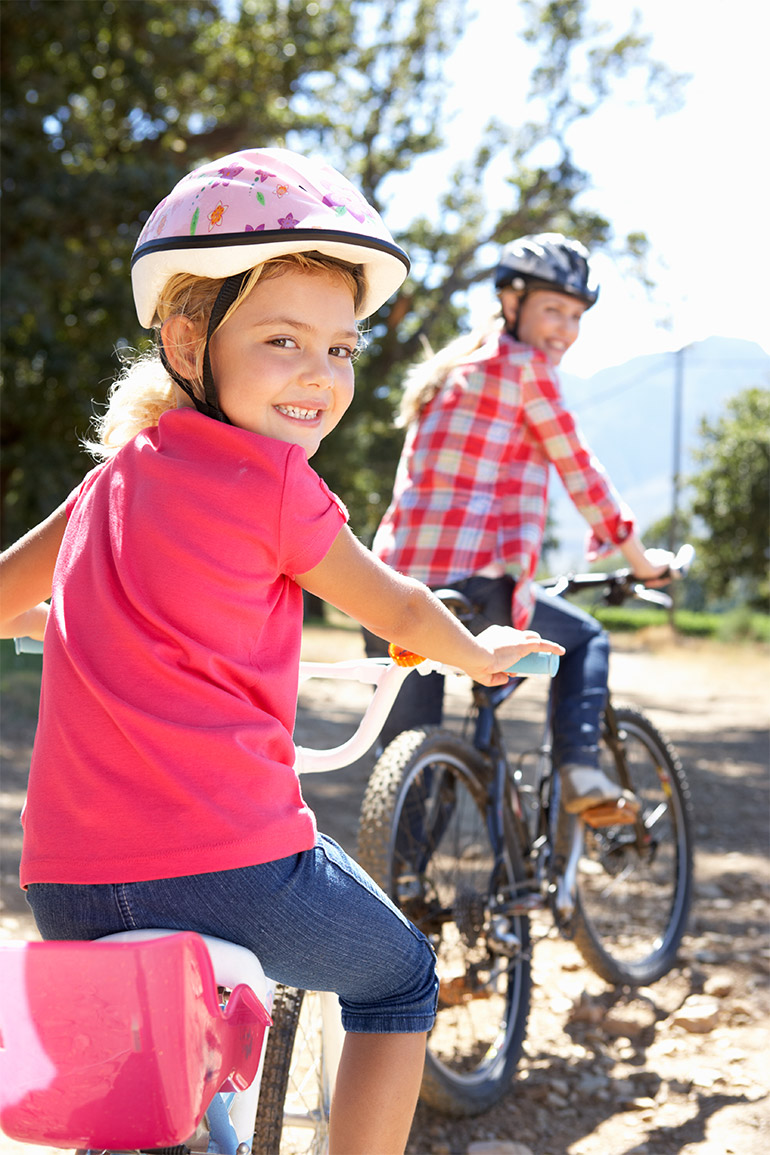 Two bicyclists smile at the camera.