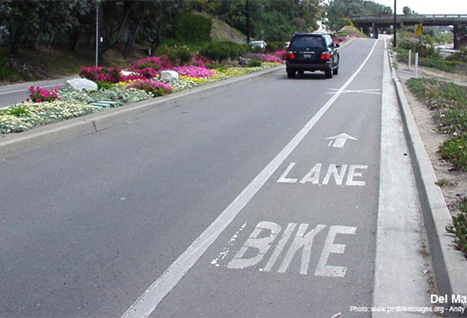 A car drives alongside a marked bike lane.