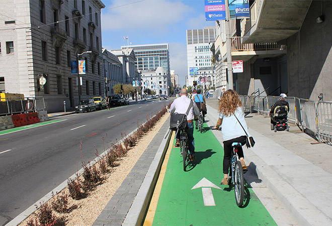 Bicyclists ride on a separated bike lane.